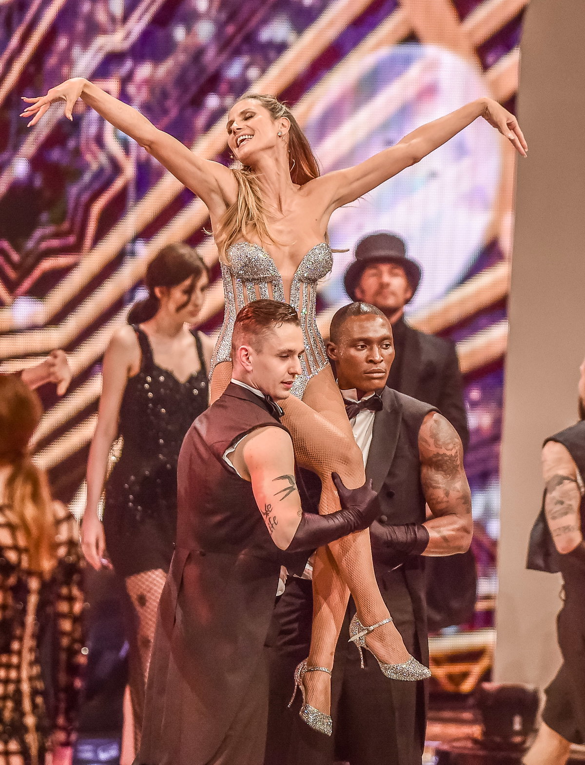Heidi Klum wird von Tänzern hochgehoben im GNTM-Finale 2017