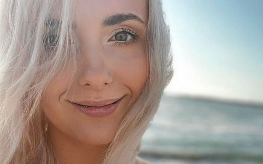 Anna Heiser mit blonden Haaren lächelt am Meer