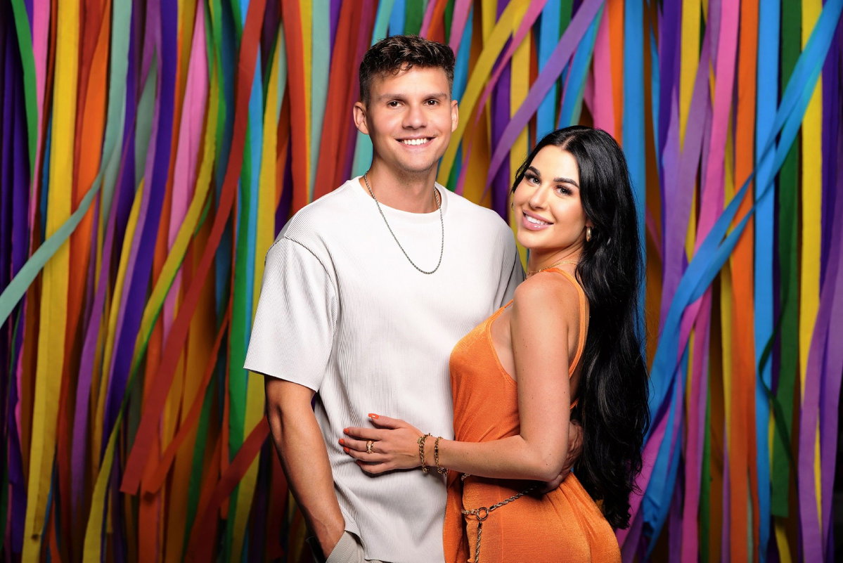 "Sommerhaus der Stars"-Paar Lisa Weinberger und Marcel Dähne vor bunter Wand