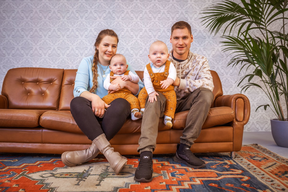 Sarafina und Peter Wollny sitzen mit ihren Zwillingen Emory und Casey auf dem Sofa.