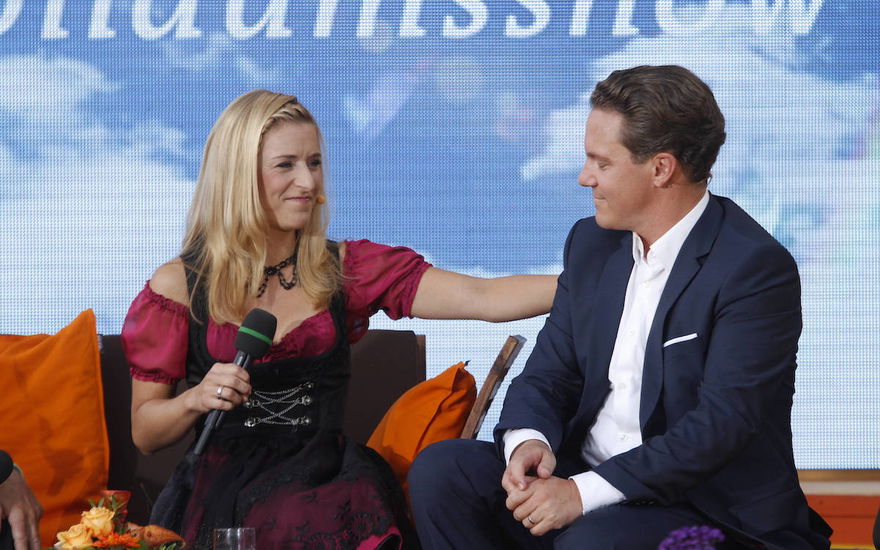 Stefanie Hertel und Stefan Mross sitzen sich auf einen Sofa gegenüber und schauen sich an