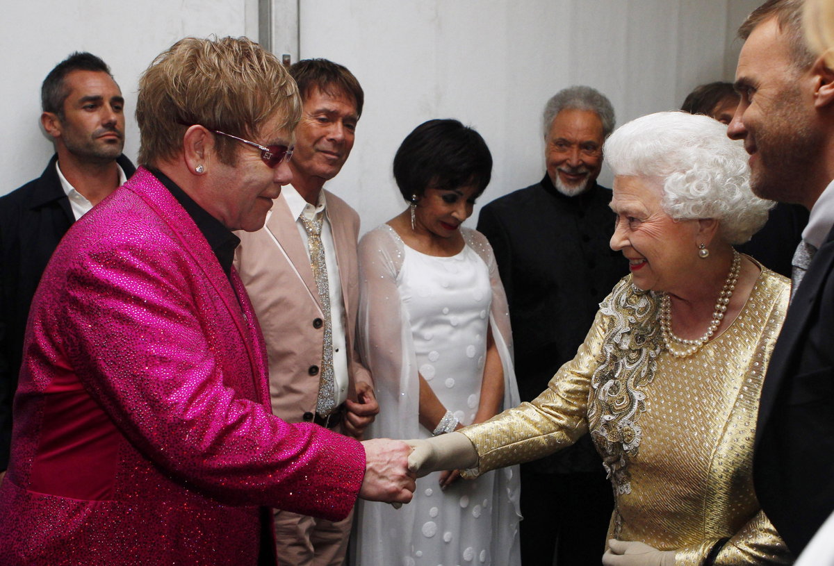 Elton John schüttelt der lächelnden Queen Elizabeth die Hand