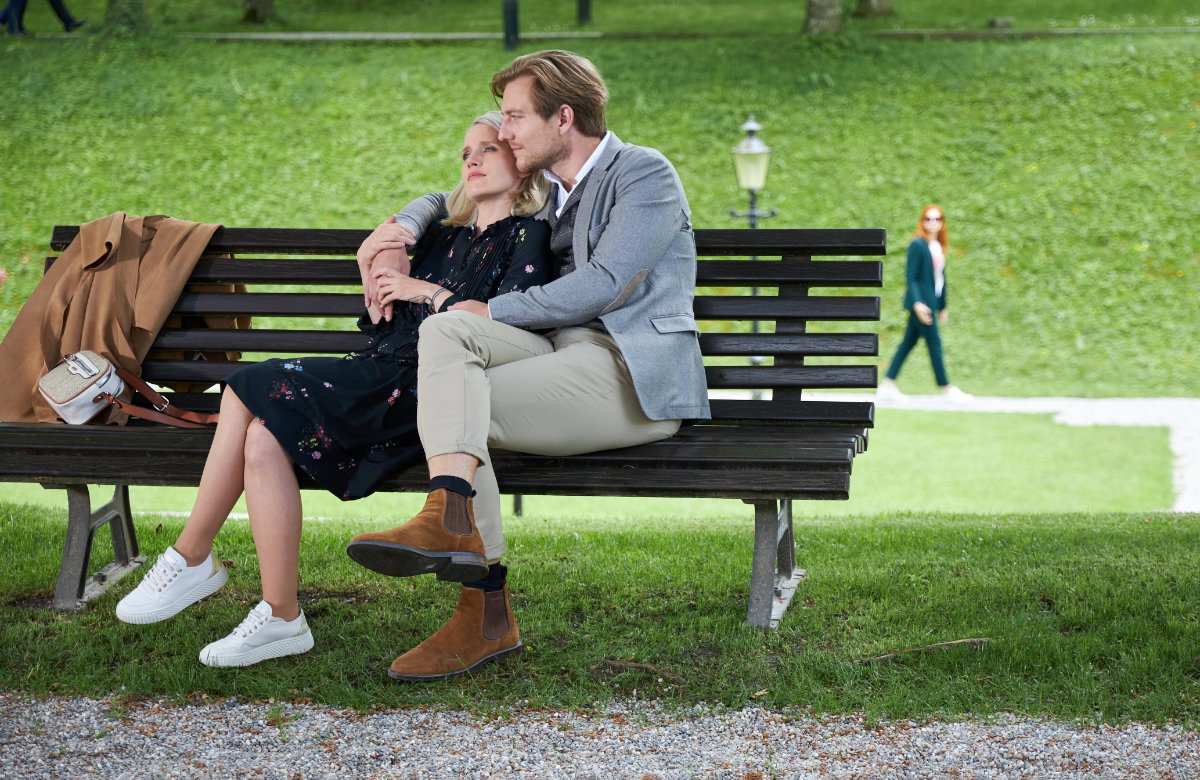 Henning und Nina sitzen kuschelnd auf einer Bank
