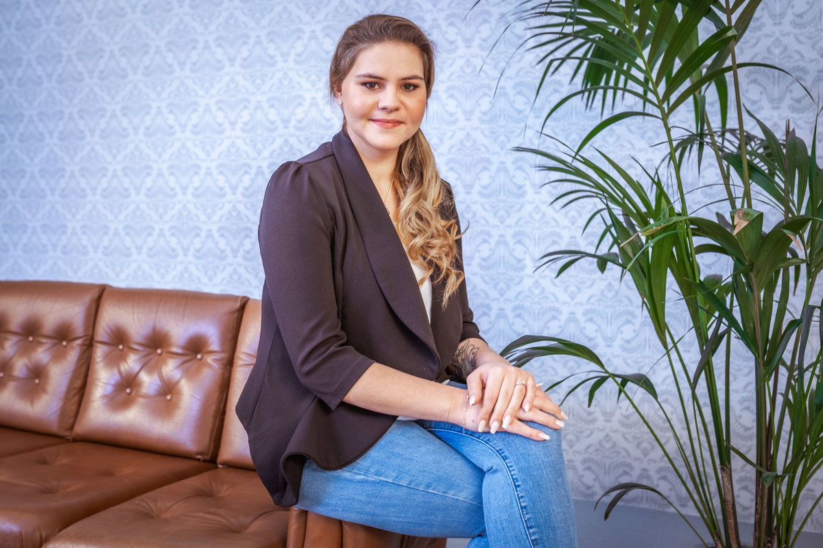 Sylvana Wollny sitzt auf der Lehne einer Couch.