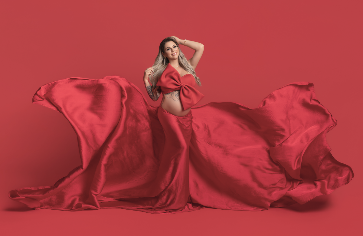 Jenny Frankhauser schwanger mit Babybauch und Schleife im roten Kleid
