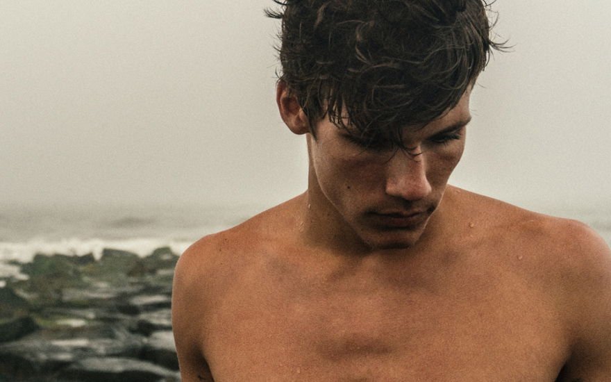 Mann oben ohne am Meer