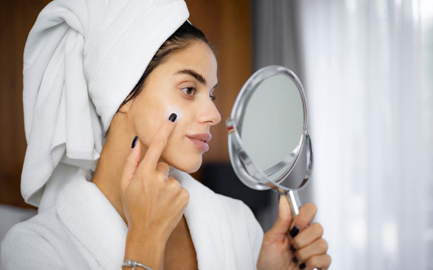 Frau trägt im Rahmen der Anti-Aging-Creme eine Feuchtigkeitscreme auf