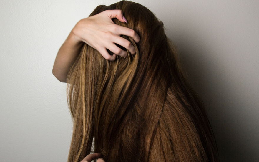 Frau fasst sich ins Haar