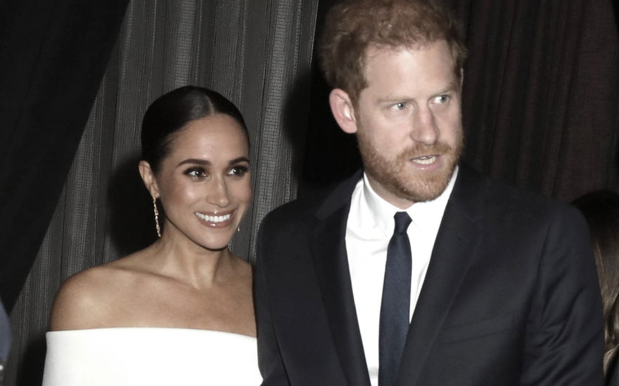 Herzogin Meghan lächelt, Prinz Harry schaut sauer
