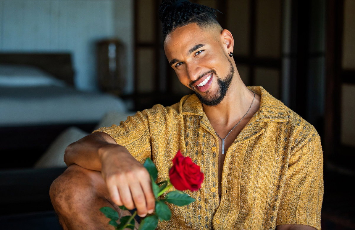 Bachelor David Jackson lächelt und hält eine Rose in der Hand.