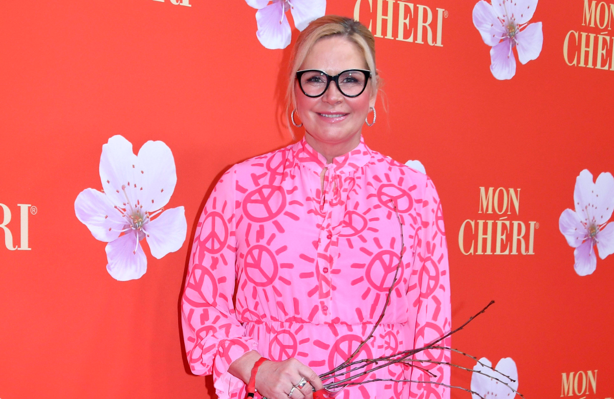 Claudia Effenberg posiert vor einer roten Wand