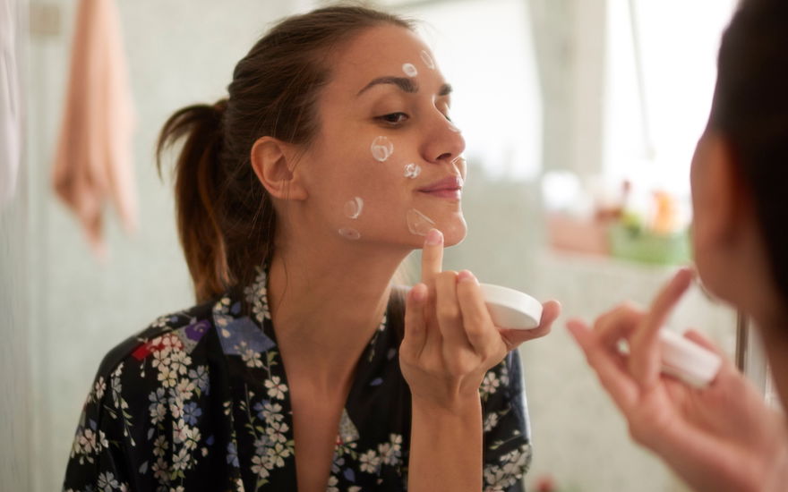 Frau mit Anti-Aging-Creme-Tupfer im Gesicht