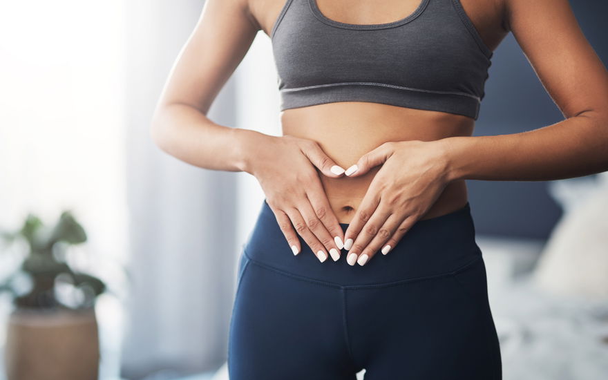Frau formt Herz über Bauch