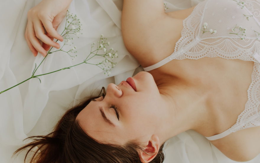 frau liegt im bett mit blumen