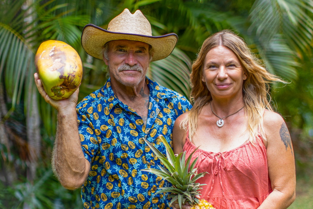 Konny und Manuela Reimann vor Palmenblättern