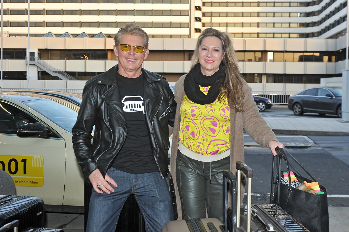Markus Mörl und Yvonne König stehen mit Koffern vor einem Gebäude