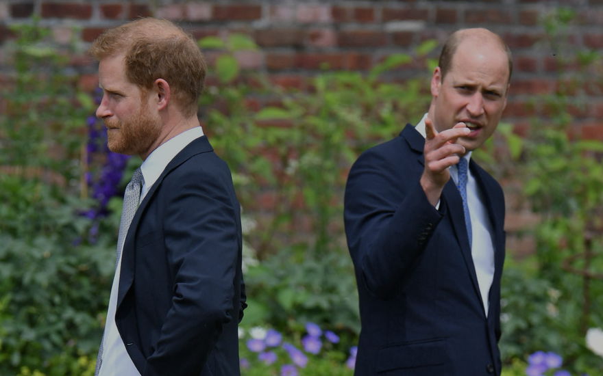 Prinz Harry und Prinz William stehen mit dem Rücken zueinander.