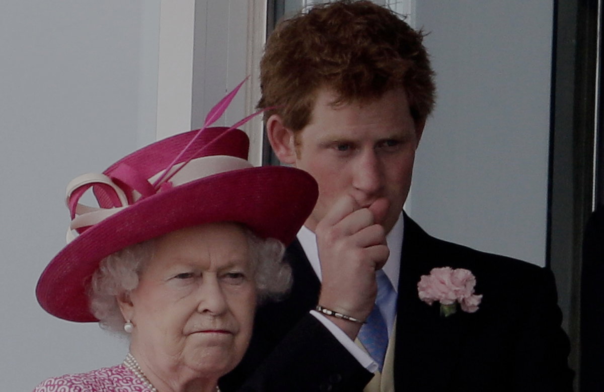 Queen Elizabeth II. und Prinz Harry schauen ernst.