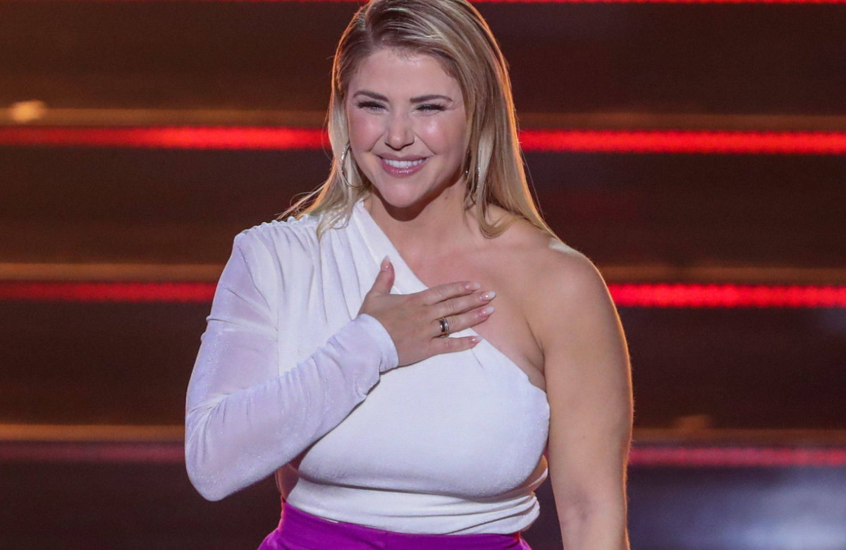Beatrice Egli lacht und hat die Hand auf der Brust