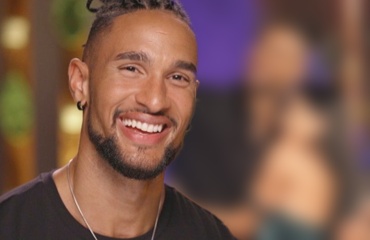 David Jackson lächelt, im Hintergrund David verschwommen mit einer "Bachelor"-Kandidatin