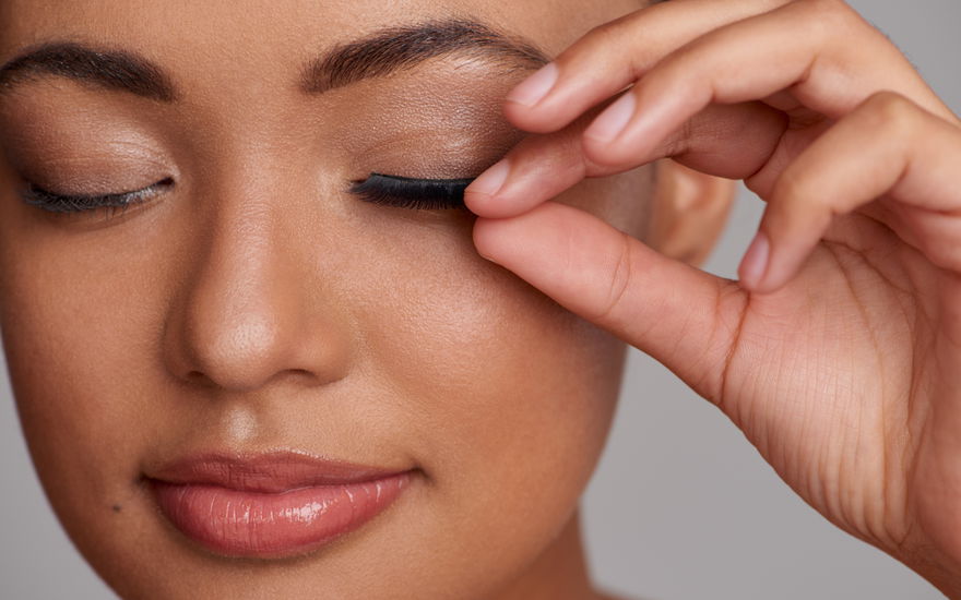 Frau fasst an Wimpern