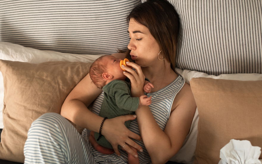 Frau mit Baby im Bett