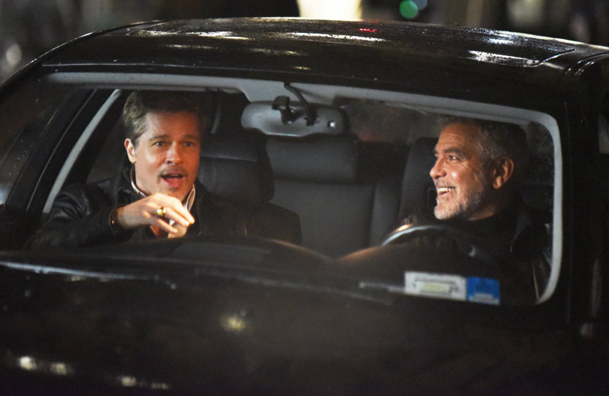 George Clooney und Brad Pitt lachen im Auto am Filmset von Wolves
