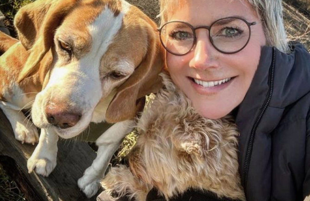 Inka Bause lächelt in die Kamera mit zwei Hunden