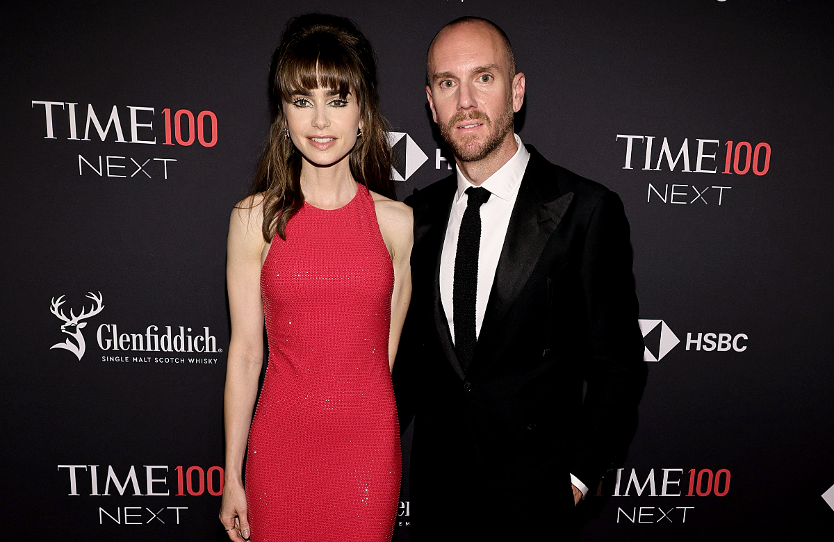 Lily Collins und Charlie McDowell posieren vor einer dunklen Wand