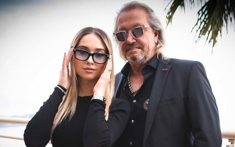 Shania Geiss fasst sich an ihre Sonnenbrille, Robert Geiss mit Sonnenbrille auf steht neben ihr
