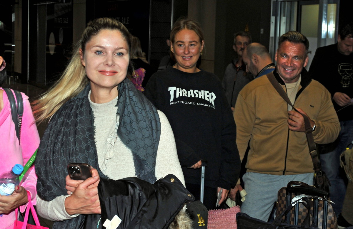 Yvonne Woelke lächelnd am Flughafen, Peter Klein im Hintergrund