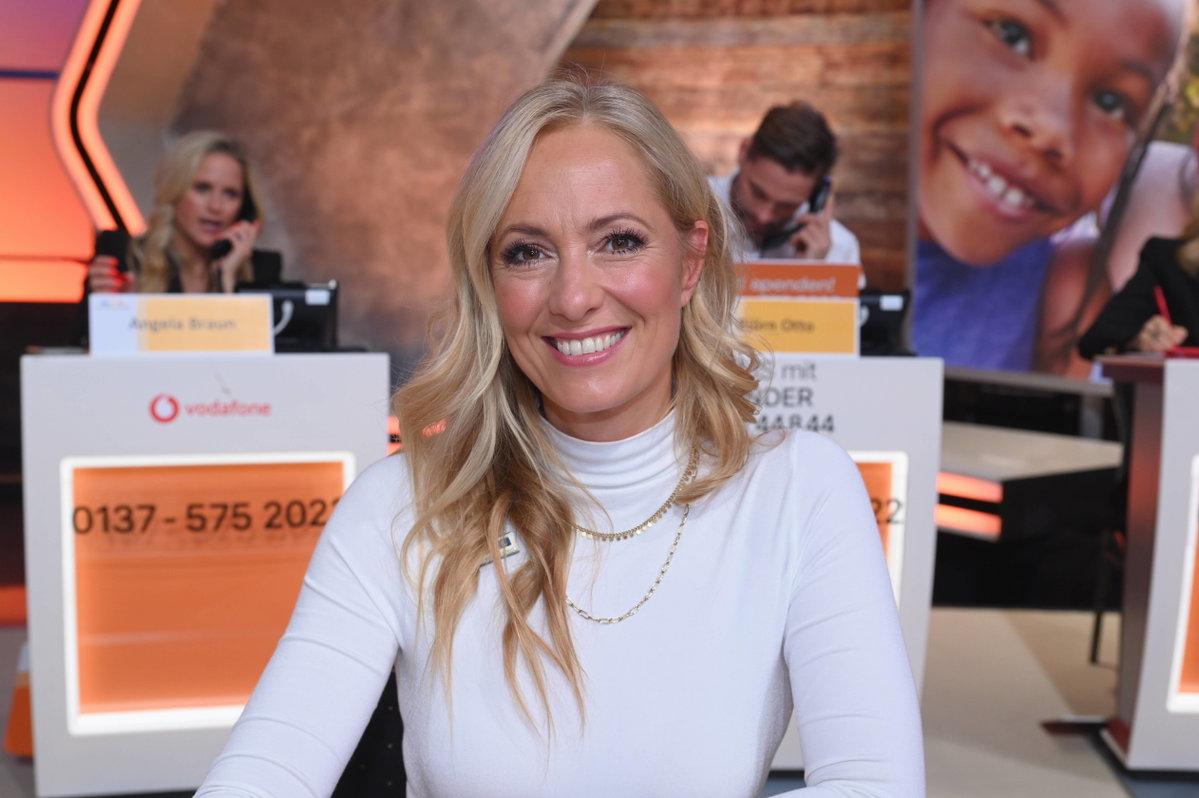 Angela Finger-Erben grinst in die Kamera im Studio