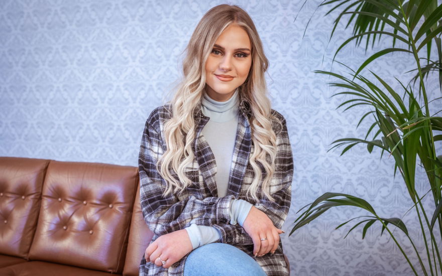 Estefania Wollny sitzt auf der Sofalehne