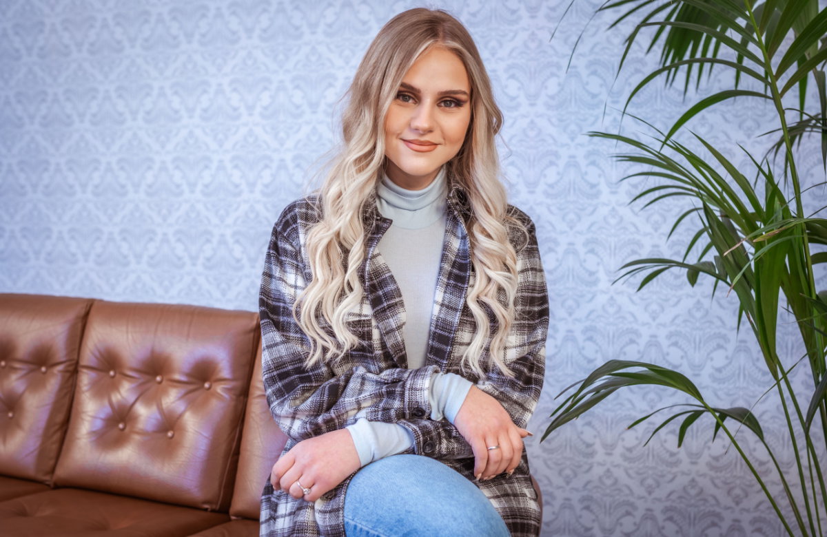Estefania Wollny sitzt auf der Sofalehne