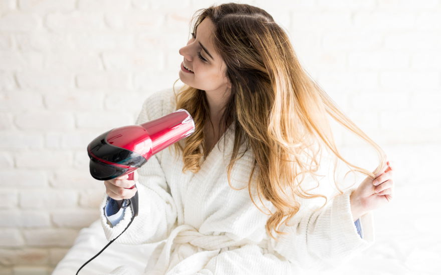 Frau föhnt Haare