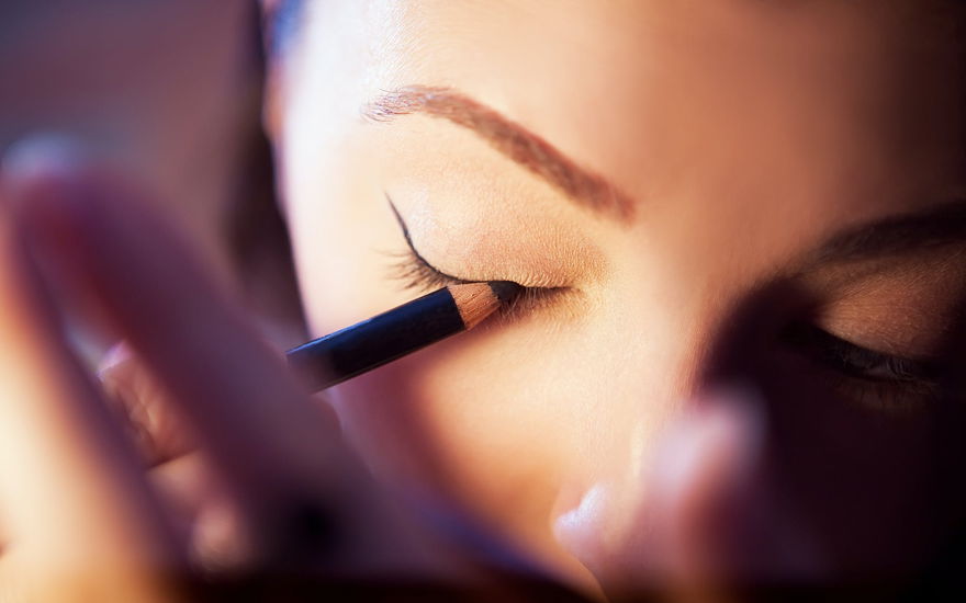 Frau schminkt sich mit Eyeliner
