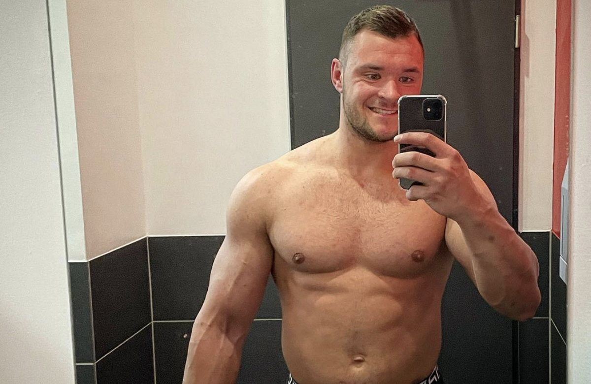 Leon Legat oberkörperfrei lächelt bei Selfie.