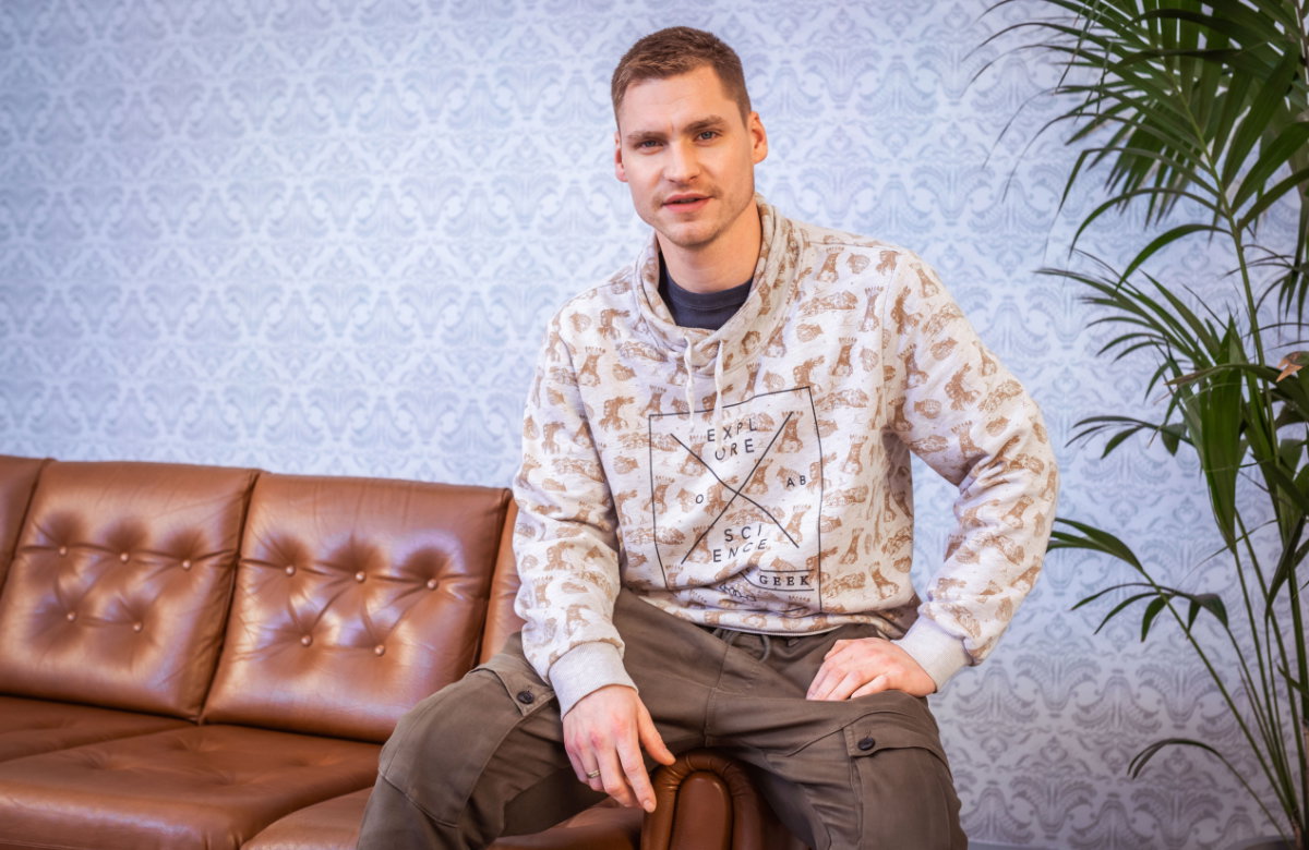 Peter Wollny sitzt auf einer Sofalehne