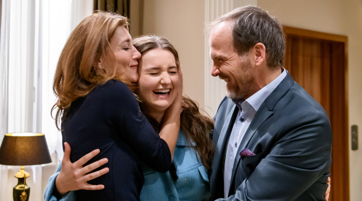 Sturm der Liebe Alexandra und Markus halten Vroni zwischen sich im Arm, alle drei lachen