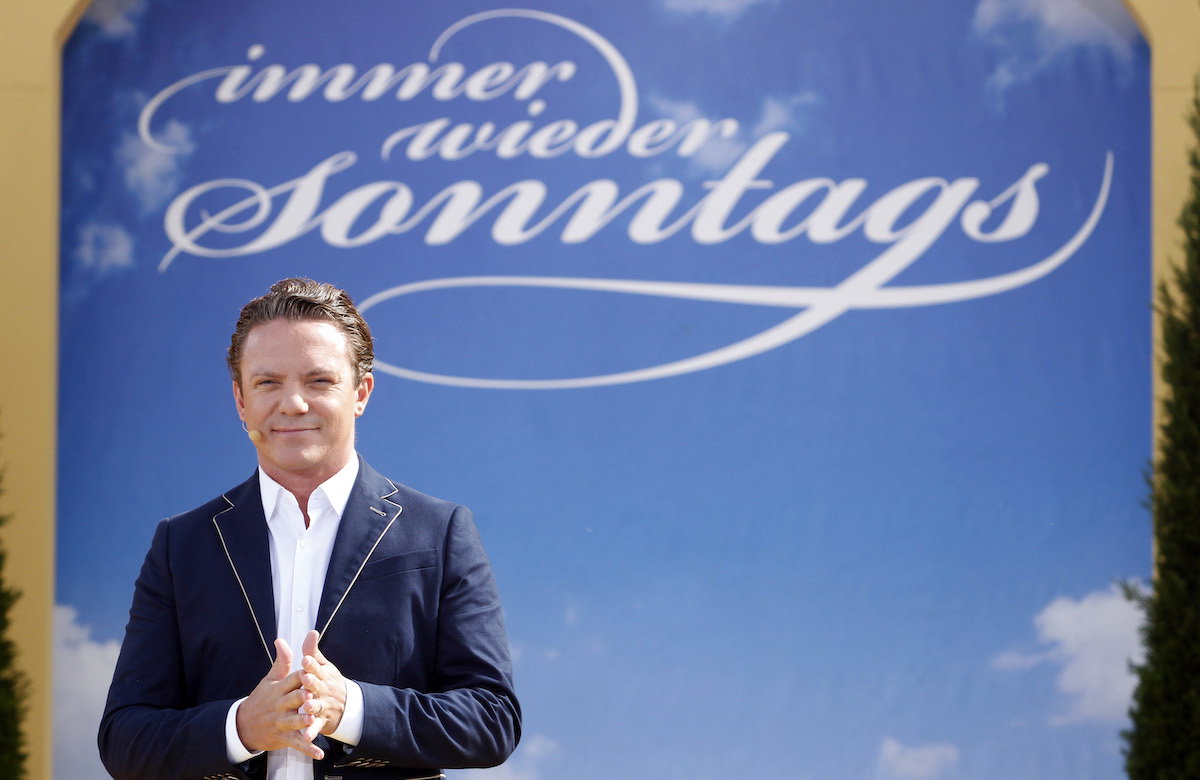 Stefan Mross mit Immer wieder sonntags Logo im Hintergrund