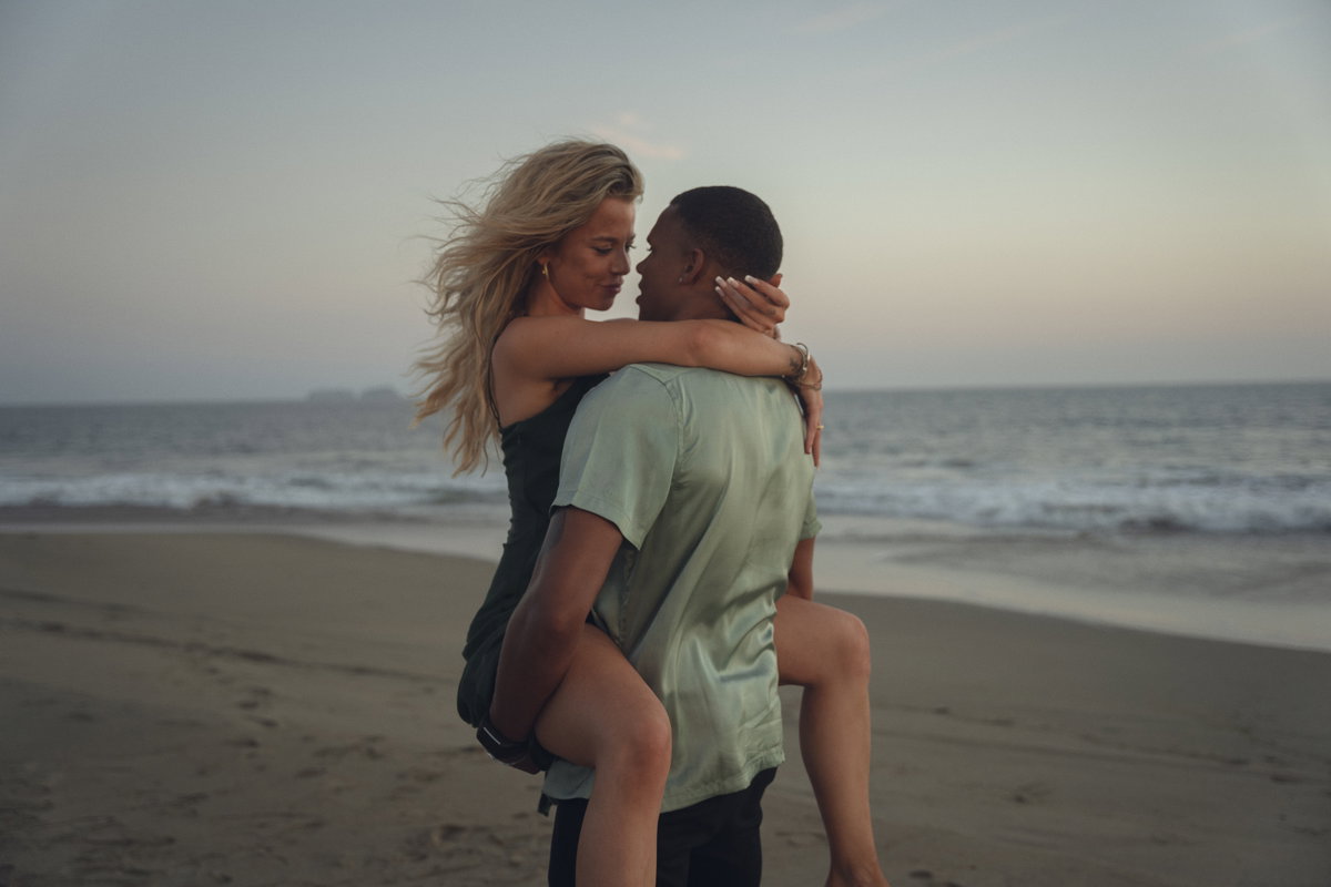 Too Hot To Handle Kevin trägt Emely auf dem Arm am Strand