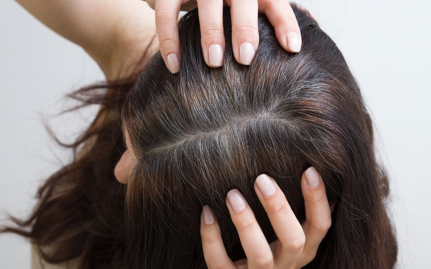 Frau zeigt graue Haare