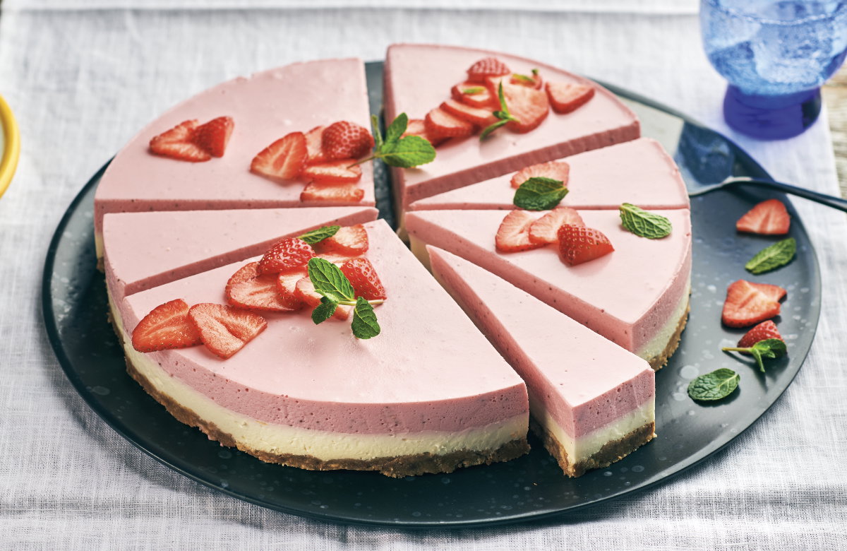 Erdbeerkuchen mit Keksboden auf einem Teller.