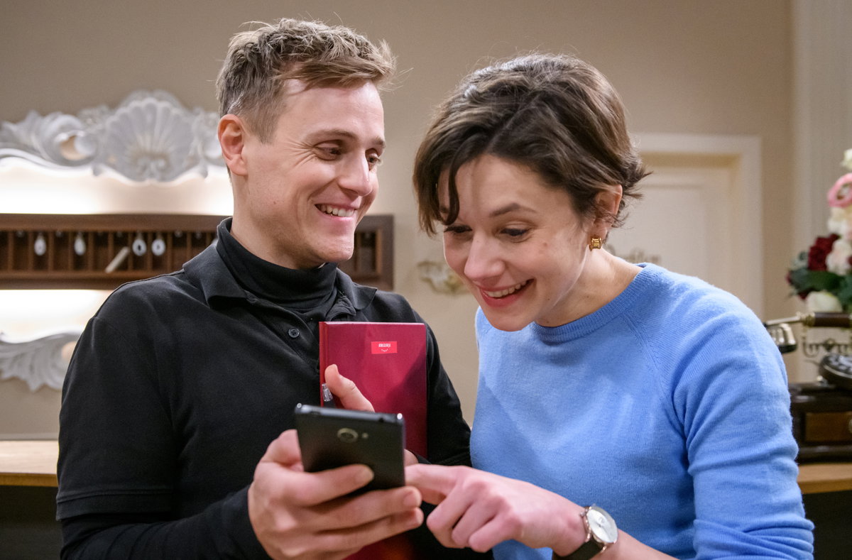 Sturm der Liebe Max zeigt Eleni etwas auf dem Handy beide lachen