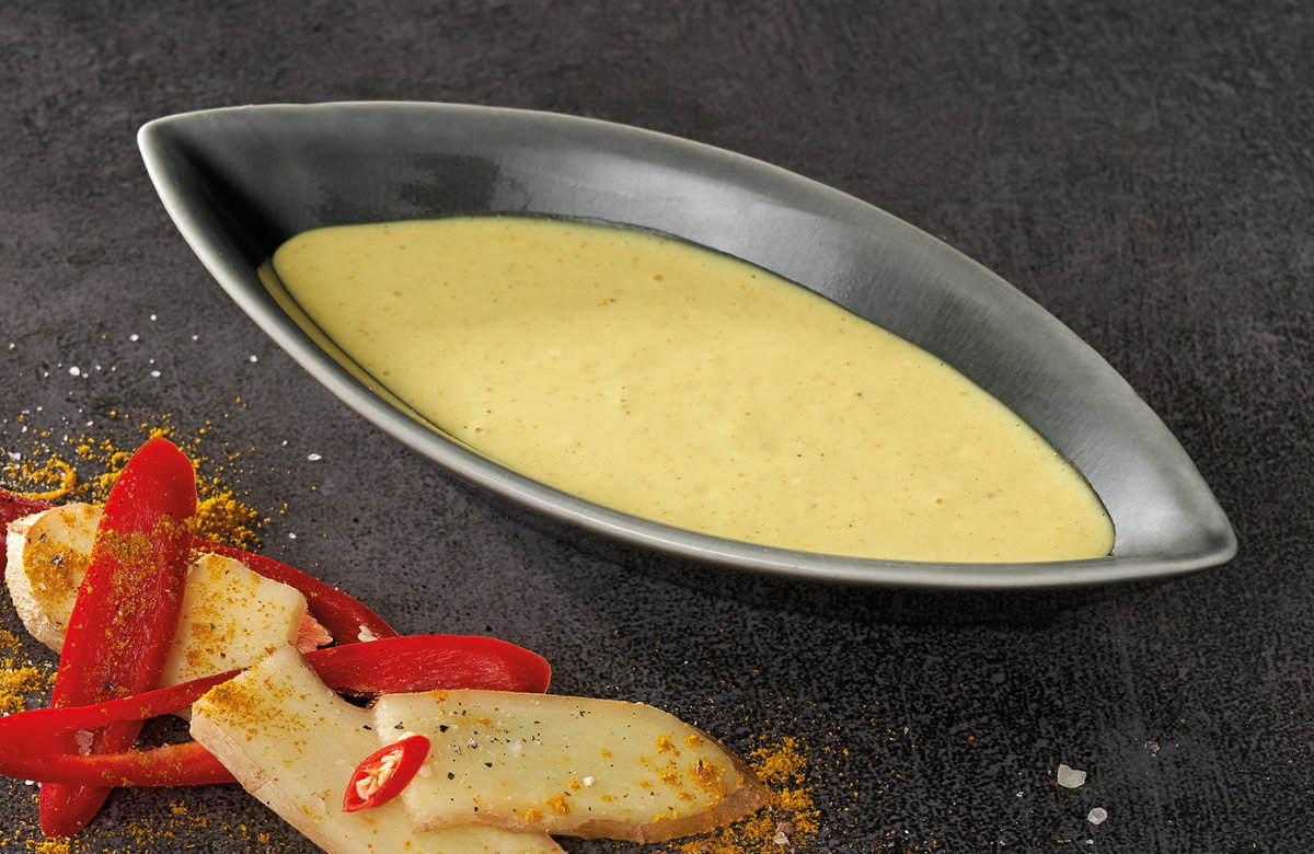 Curry-Dip India mit Ingwer daneben auf dunklem Untergrund