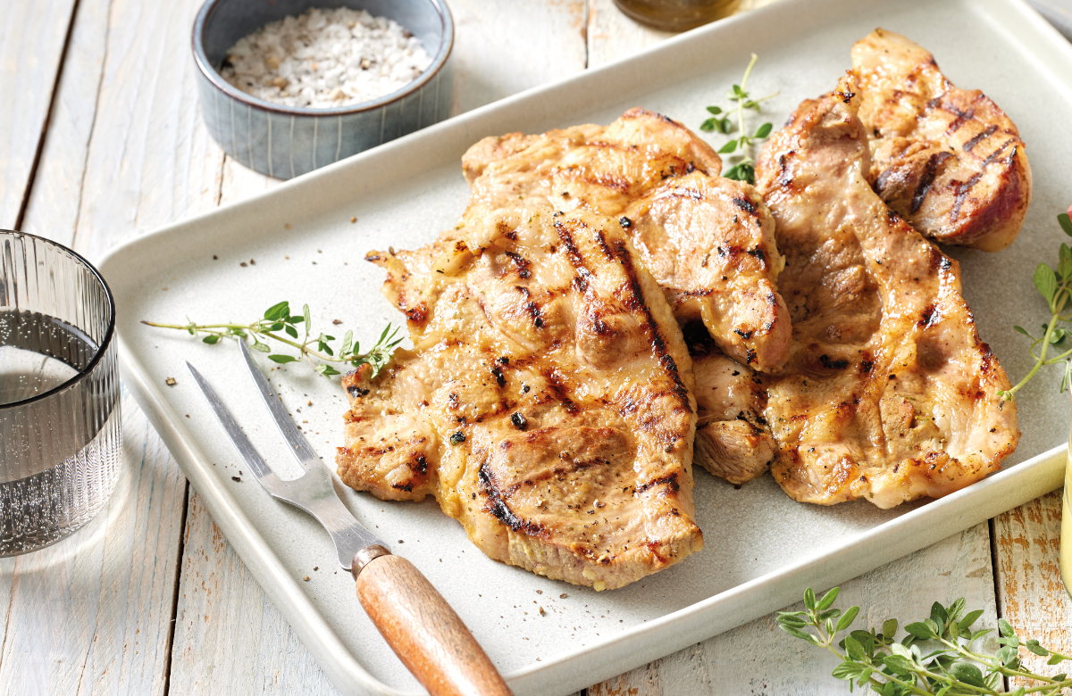 Gegrillte Nackensteaks in Bier-Marinade auf einem Teller