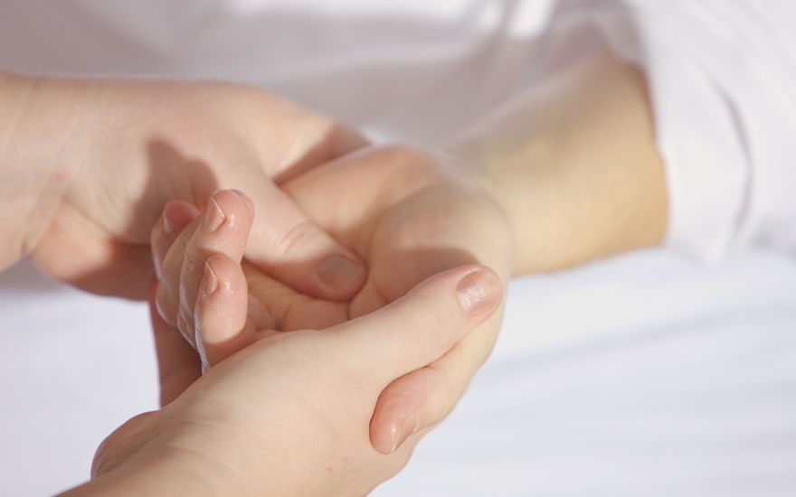 Zwei Hände massieren eine andere Hand
