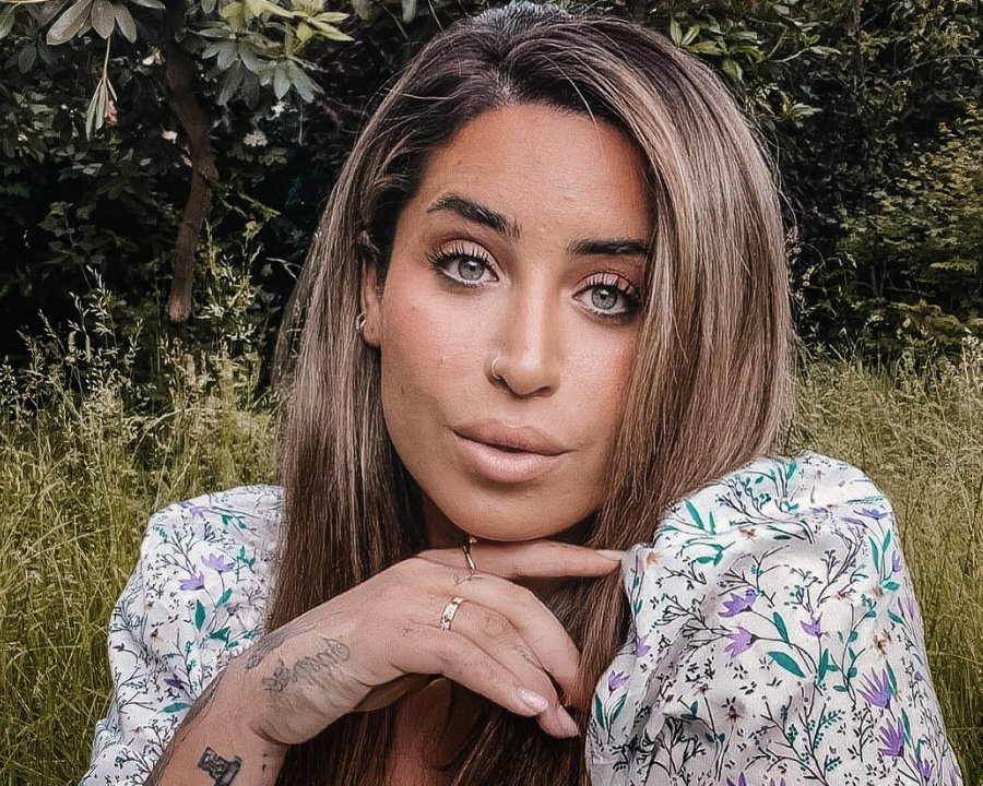 Jolina Mennen macht ein Selfie im Garten und trägt ein Blümchenkleid