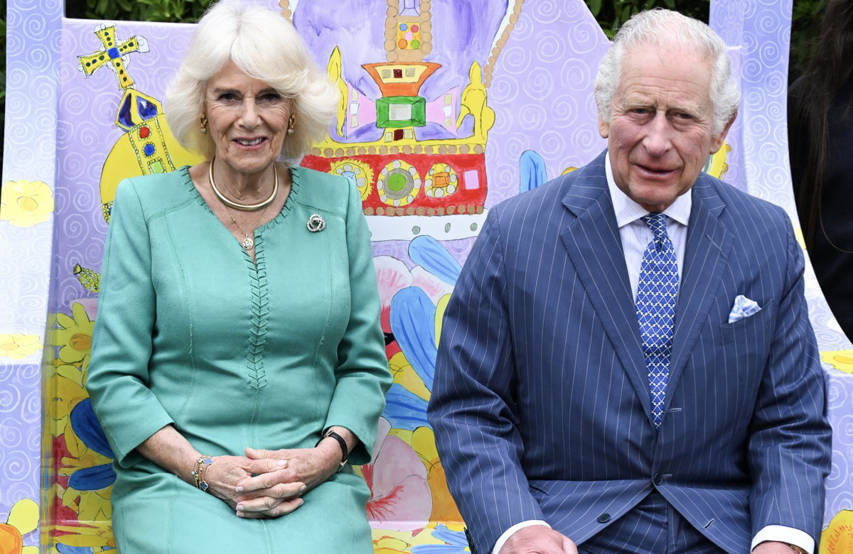 Königin Camilla und König Charles sitzen auf einem nachgebauten Thron.