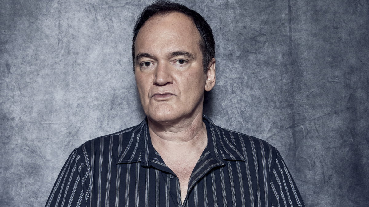 Quentin Tarantino trägt ein gestreiftes Hemd und sieht ernst in die Kamera